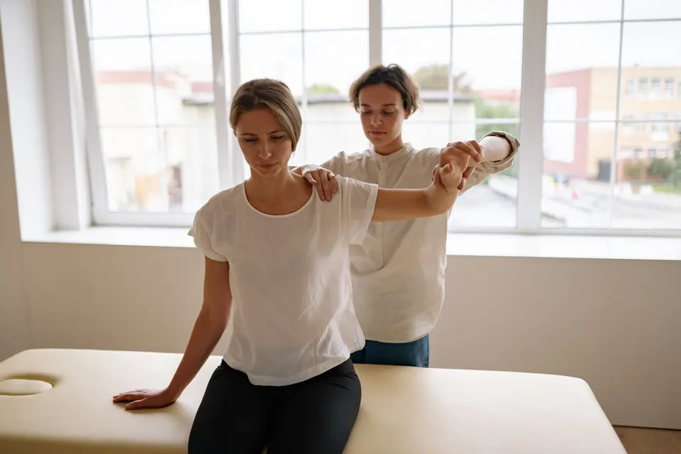 Terapeuta estirando el brazo de una paciente
